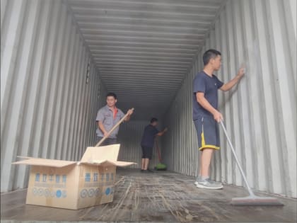 Empty shipping container being cleaned before loading furniture goods