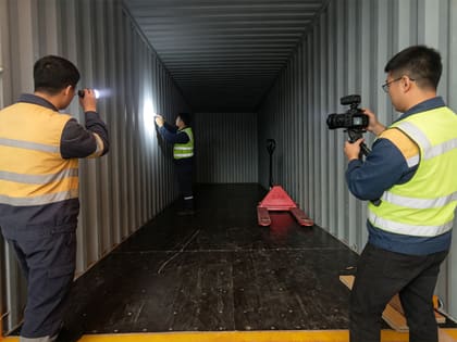 Factory team recording video documentation inside the container